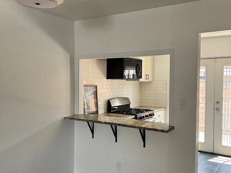 Open concept from living room into kitchen, charming breakfast bar.