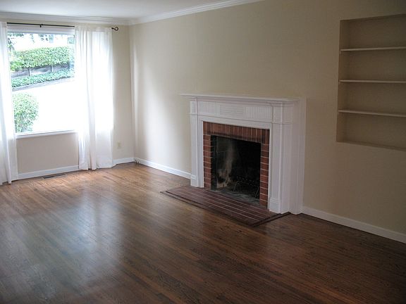 Living Room with Hardwood Floors, Crown Molding and Wood Burning Fireplace