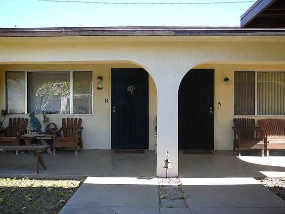 Front facing view of duplex building. The common cemented area is on the left & carport to the right in front of the building.