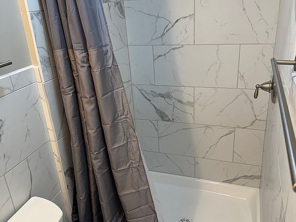 Remodeled bathroom, tiled shower, flooring.