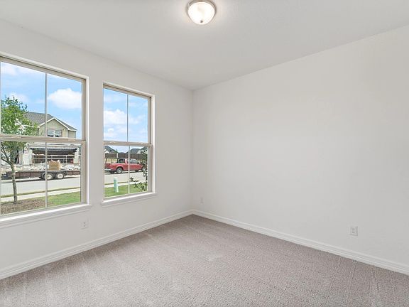The third bedroom features plush carpet, fresh paint, closet, and a large window that lets in plenty