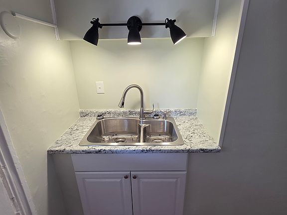 New kitchen sink, cabinet, coutertop, and lighting.
