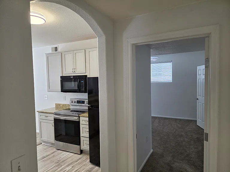 View of kitchen from hall leading into the primary bedroom/bath/balcony