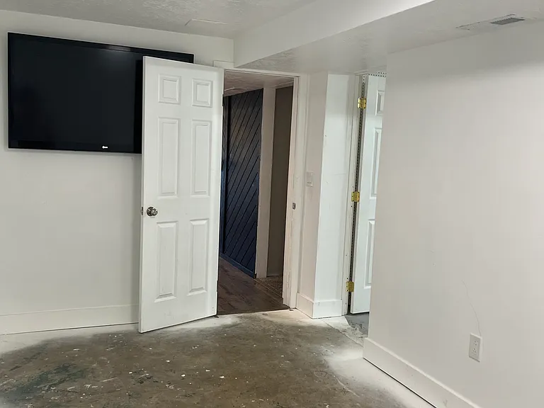 Downstairs gym. Door on right leads to storage, door on left leads to stairs and living room