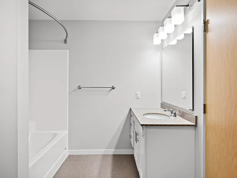 Modern bathroom featuring a sleek vanity with elegant lighting, a spacious mirror, and a pristine shower area. Ideal for contemporary living. Modern bathroom featuring a sleek vanity with elegant lighting, a spacious mirror, and a pristine shower area. Id