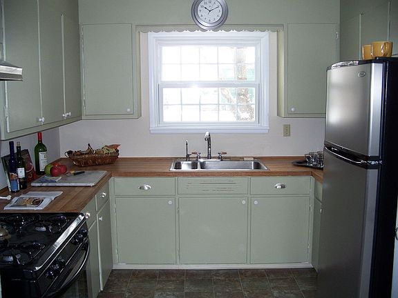The kitchen has classic original wood cabinetry and stainless appliances