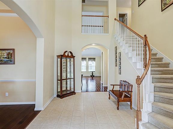 You will walk in through leaded glass front door to the two story tile entry with sweeping grand stairwell to the upstairs.