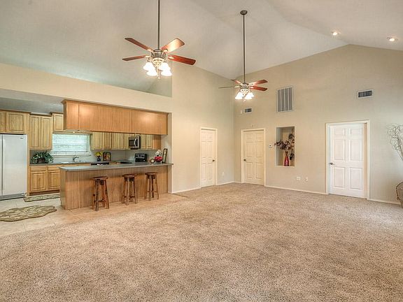 The living area offers high volume ceilings, a breakfast bar