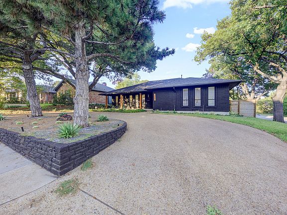 Front exterior of home with a circle drive and 2 car garage around the back