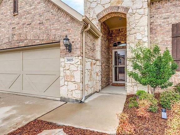 2 car garage. Notice the detail in the doors. Gutters. Coach lighting.