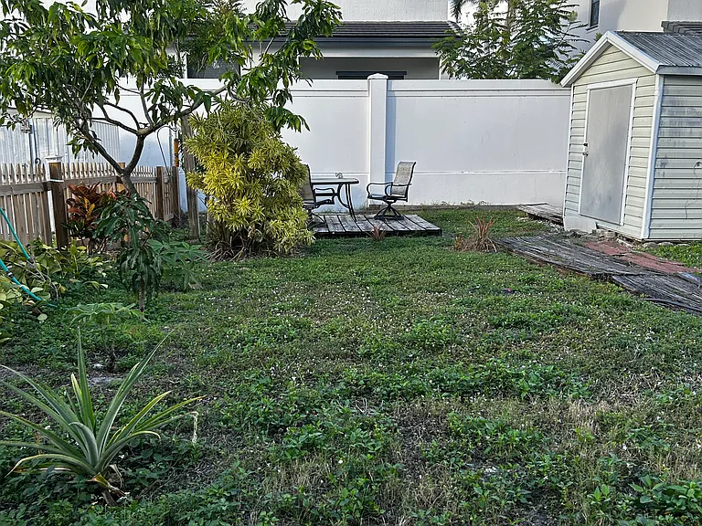 Fenced backyard with two storage sheds