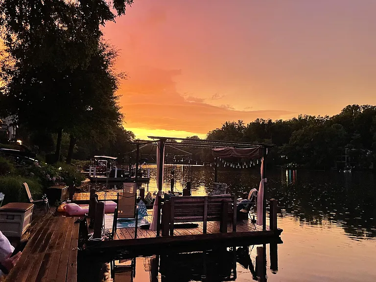 Deck boat with retractable pergola and an electric motor.