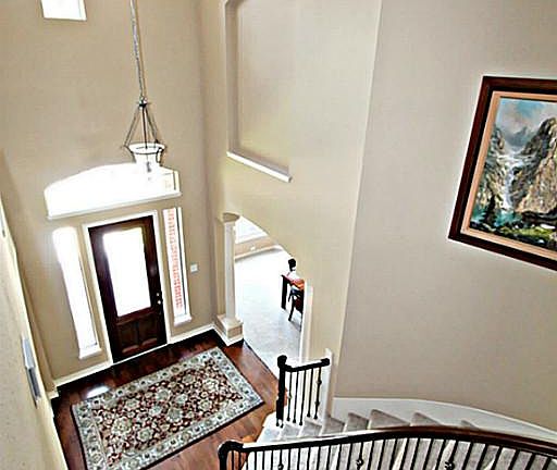 STEP INSIDE THE STUNNING TWO STORY FOYER WITH CROWN MOLDING, DAZZLING HARDWOOD FLOORS, ART NICHE, AN