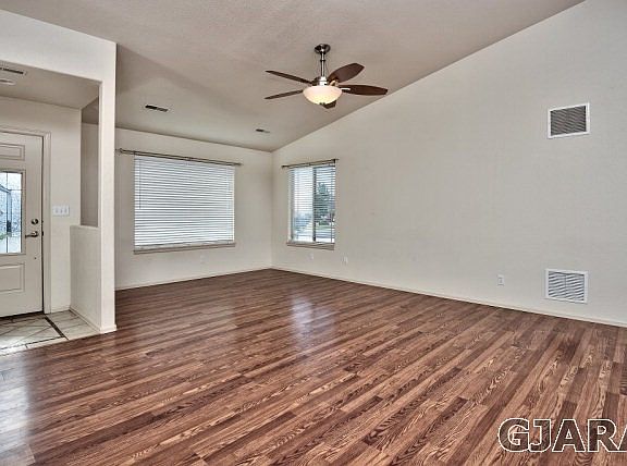 The spacious living room pairs hardwood flooring to vaulted ceilings in this Cha