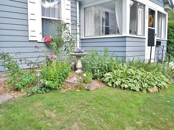 Appealing front porch entry surrounded by wonderful gardens which are full of perennials and herbs.