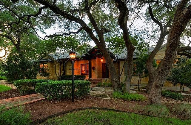 Enter under the oak canopy surrounding native landscaped beds
