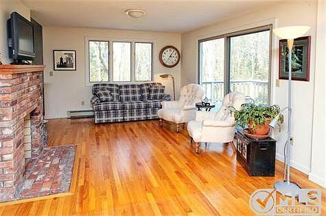 View from the kitchen of the Family Room with wood-burning fireplace and sliders to deck.