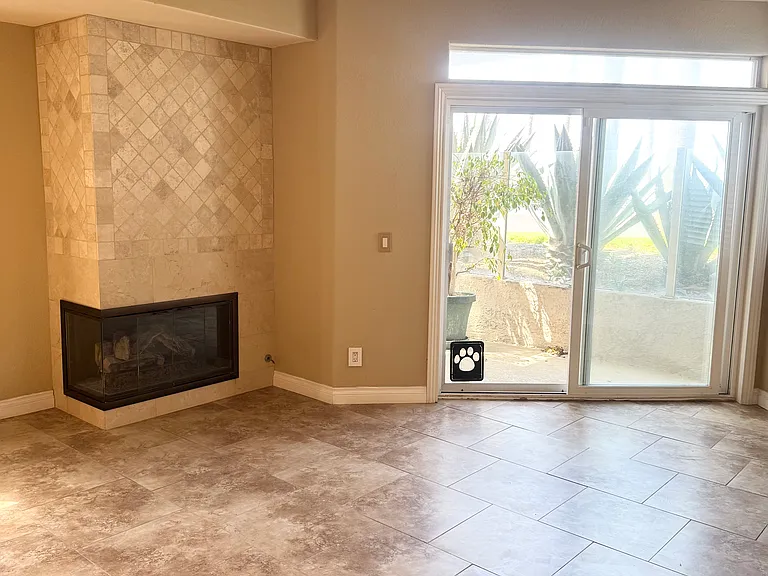 Spacious living room with stone accented fireplace and stone flooring