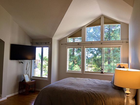 Primary bedroom with vaulted ceilings and views of nature out your windows!