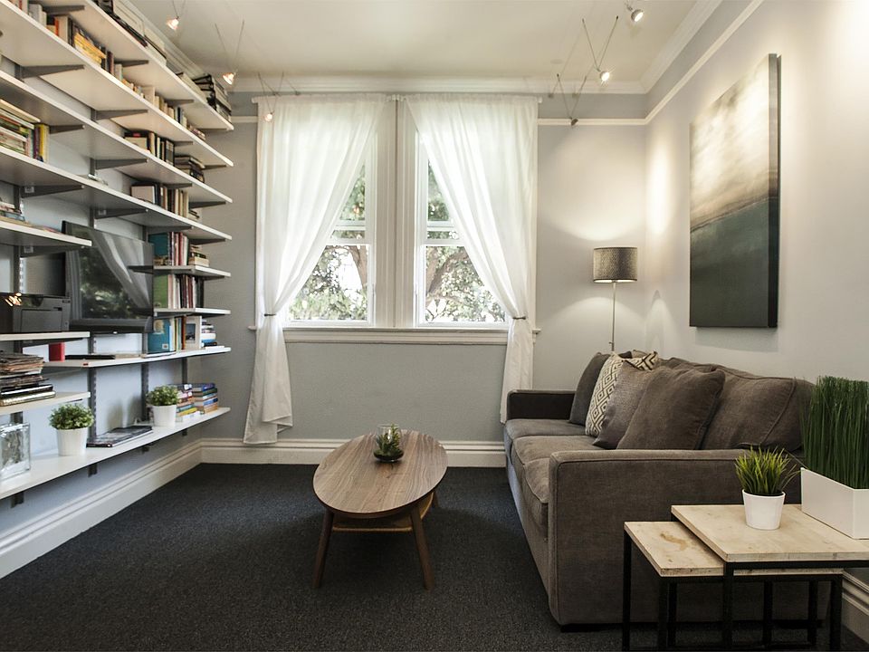 Living room, TV to left, windows on to street