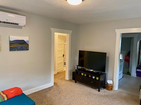Living room with view of kitchen and bathroom/hallway
