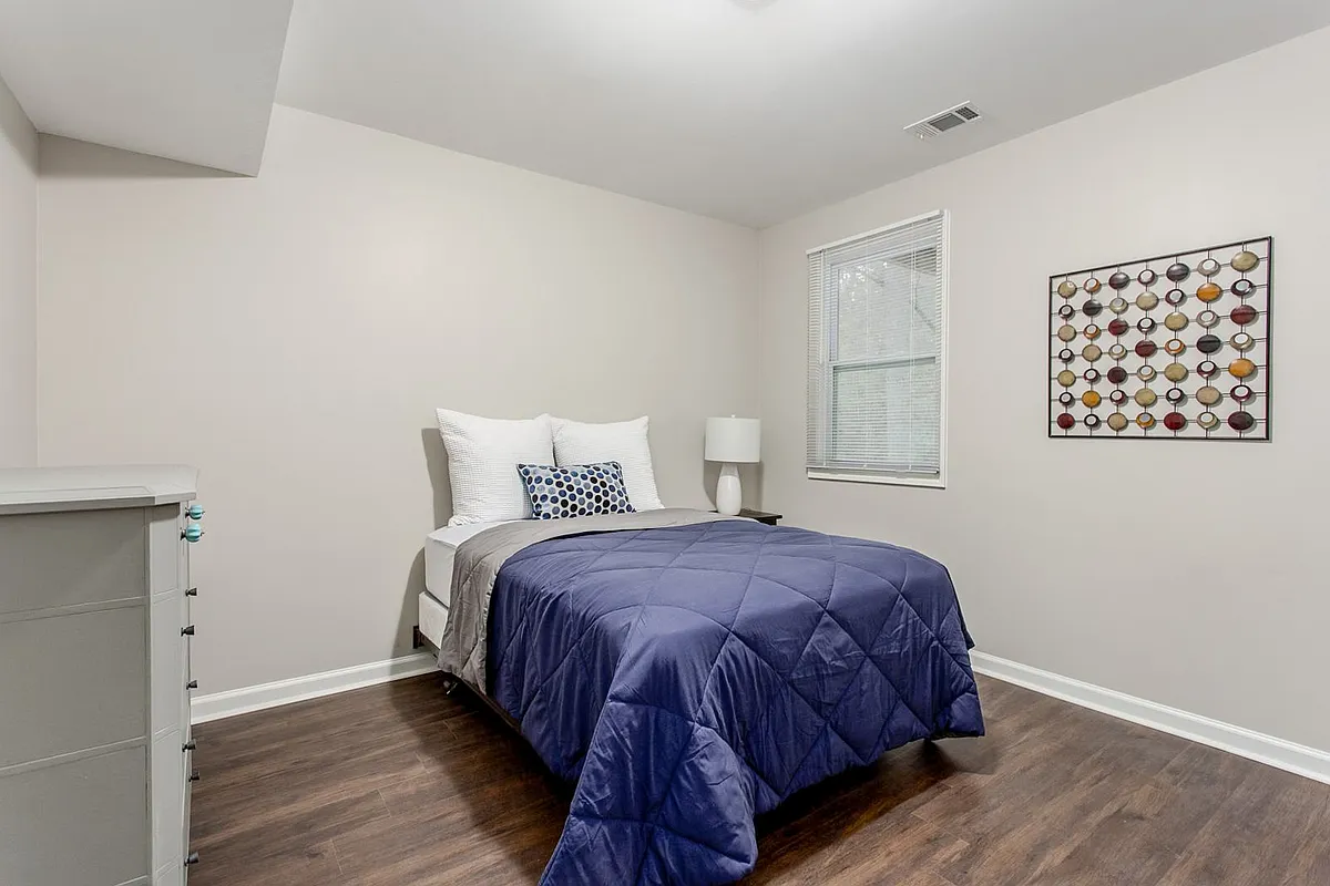 Photo 1 of 10 - Oakvale Dr - Douglasville, GA Bedroom with dresser, hanging rack, nightstand and lamp. - Oakvale Dr