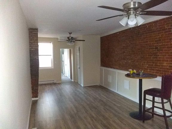 Entrance into the front living room and back dining room...wooden floors, authentic original brick view of walls