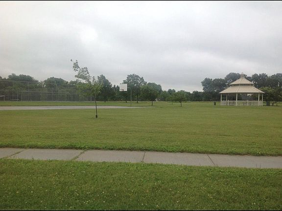 Neighborhood park with tennis courts and playground equipment across street