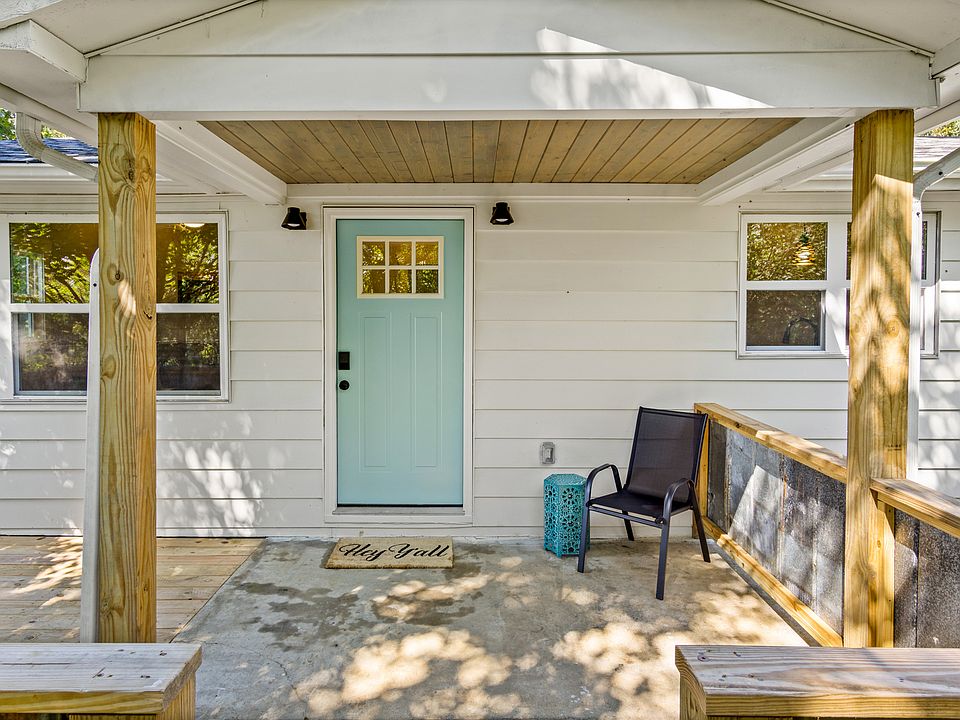 Covered front entrance with large deck off to the left.