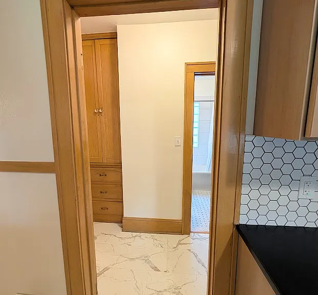 [LOWER UNIT]: Kitchen leads to living space hall with linen closet, bathroom and rooms on the left and right