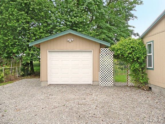 detached garage with a dog kennel in the back yard.