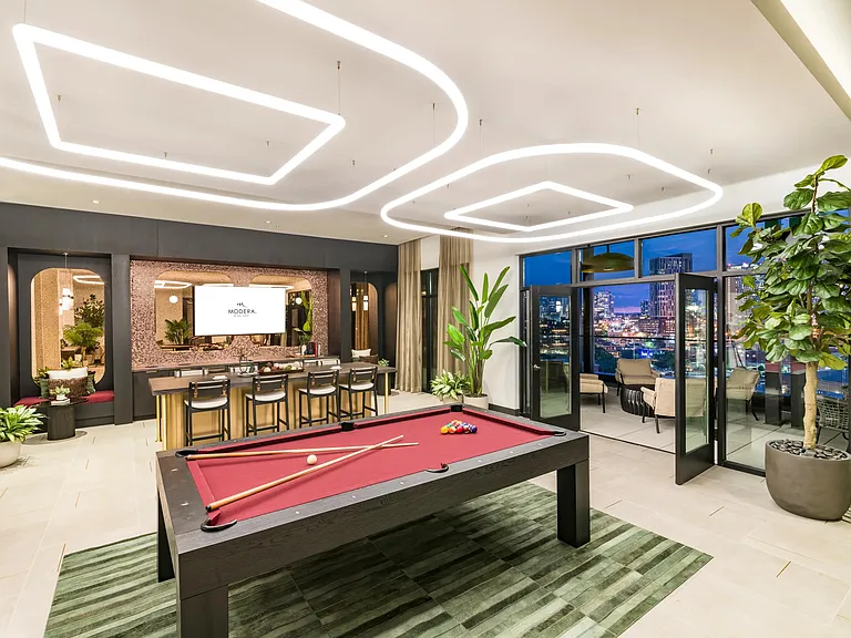 A sky lounge designed to impress_with skyline views, a billiards table, and bar seating perfect for entertaining.