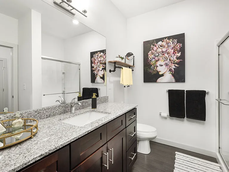 Bathroom with Granite Countertops and Wood-Inspired Flooring