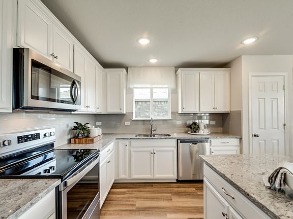 Spacious kitchen with large window, recessed lighting, and built-in appliances