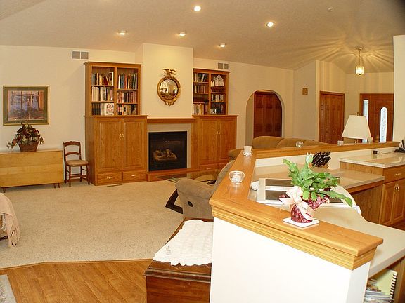 Large living room with gas fireplace and custom built in shelving.