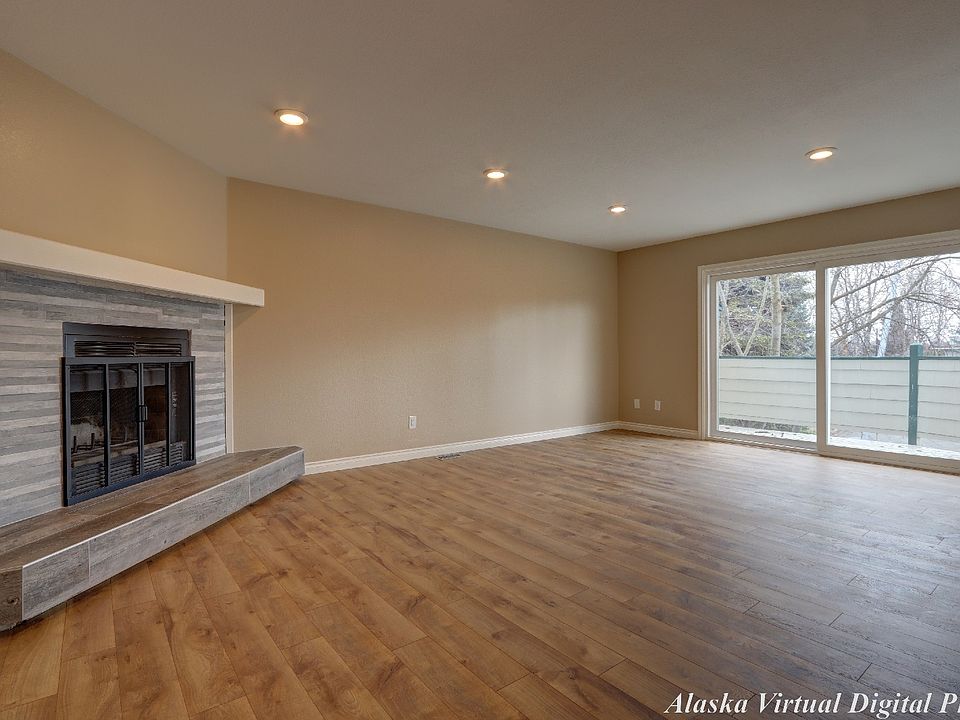 Livingroom with laminate flooring and wood burning fireplace.