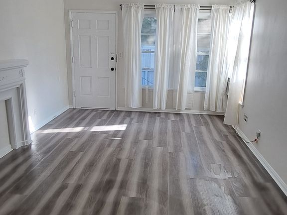 Living room 18'x12' square feet with new curtains and window AC. Faux Fire place and new floors.