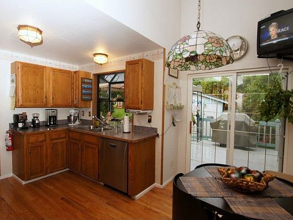 Another view of the kitchen showing the garden window, eating area and slider to deck.