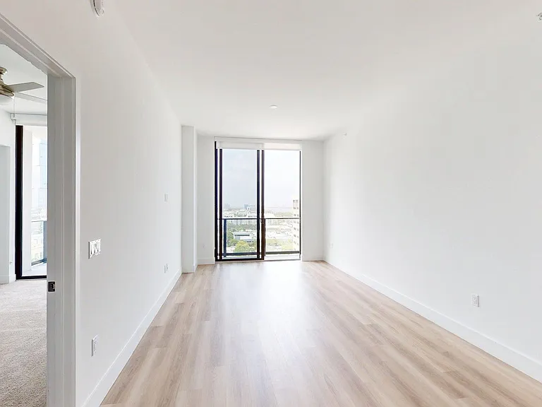 Apartment Living Room with large windows and wood-style flooring.