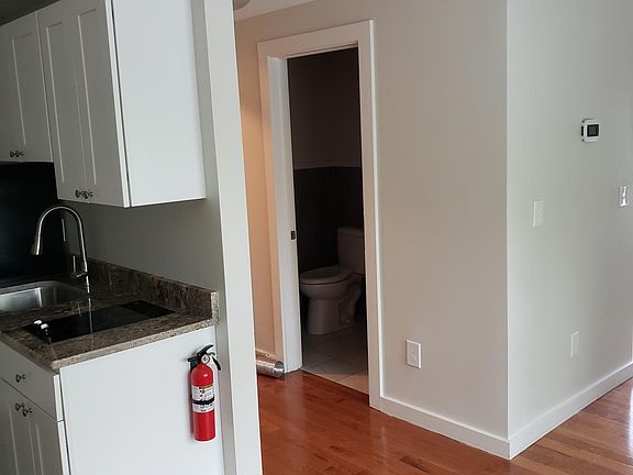 living room looking into hallway, bathroom and kitchen