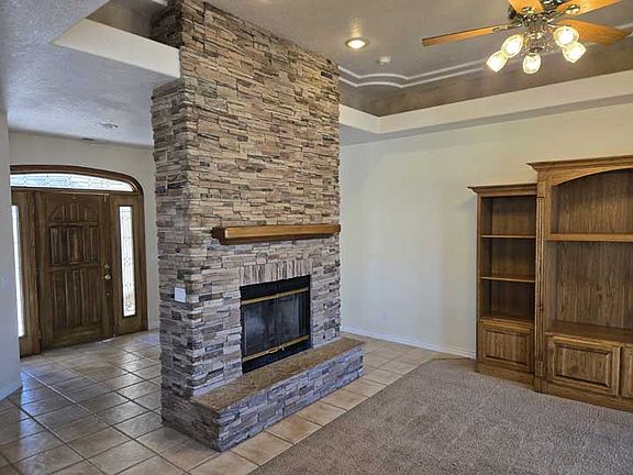 Entry with column stone fireplace in living room