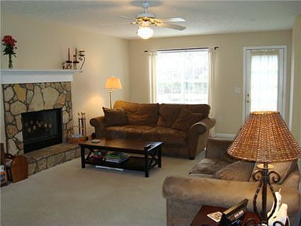 Family room with stone fireplace and exit to deck