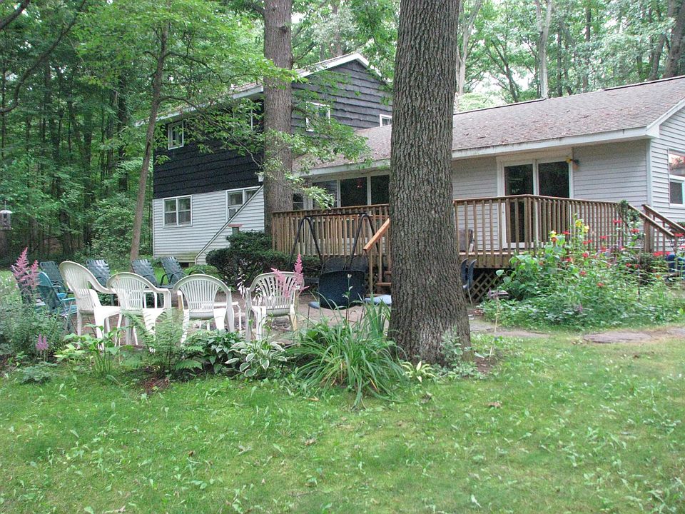 The Private Entrance to the basement apartment is the slanted roof over to the left of the deck in the back yard. The smaller Fire Pit is in front of the chairs.