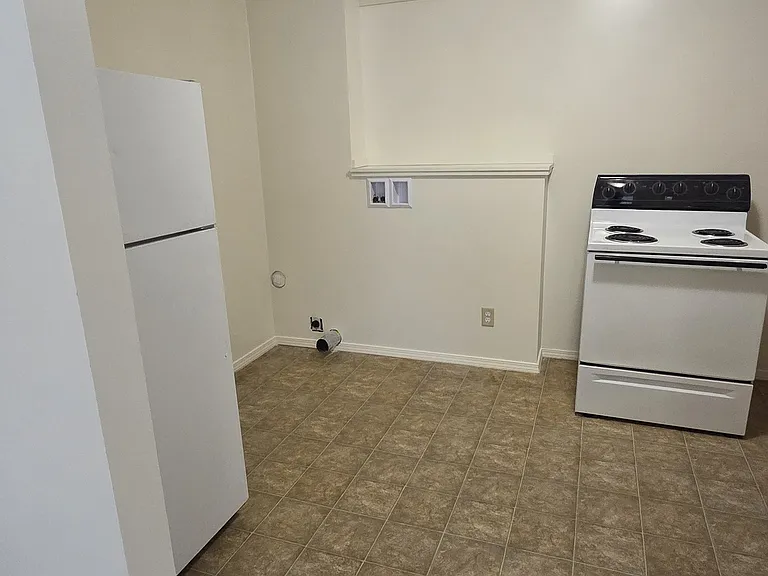 Updated kitchen space with refrigerator, electric range, and new washer and dryer hookups for in-unit laundry convenience.