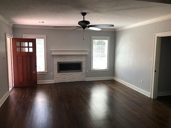 Living Room / Front Entrance, functional fireplace with small storage closet to the right.