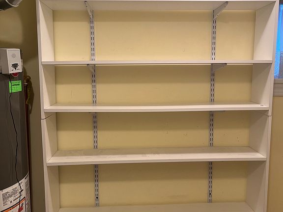 Besides a coat closet, the utility room offers lots of shelving storage