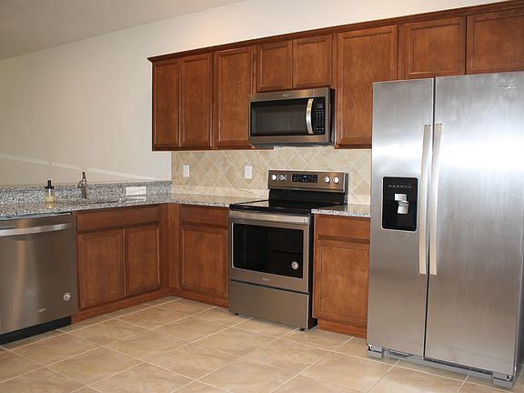 Large kitchen with granite countertops and stainless steel appliances.