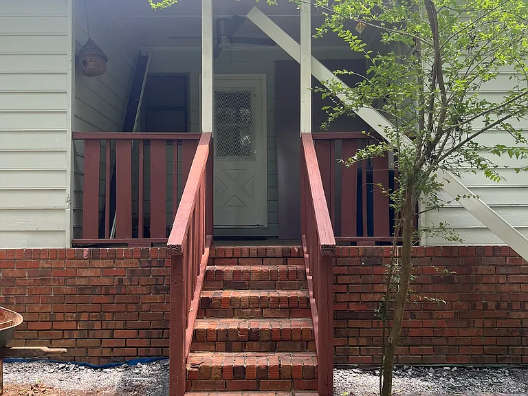 Covered back porch looking onto wooded area. (ignore gutter - it is now installed on rear of home)