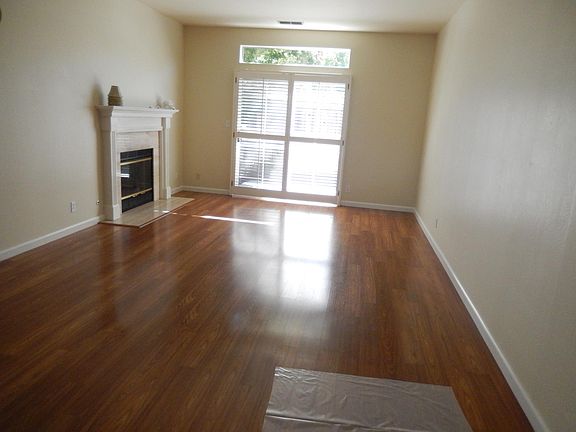 Dining room and living room with fireplace. Sliding door leading to outside patio. Hardwood floors in dining room, living room and entry.