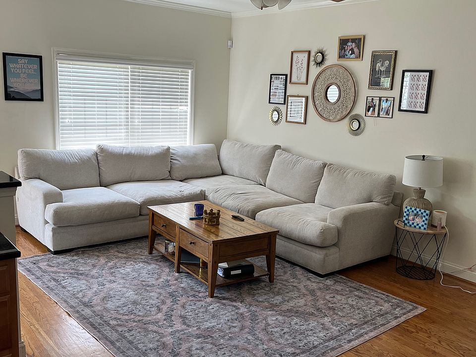 Living room with great natural light, hard wood floors and adjoining dining room and kitchen. Blinds remain, furniture does not.